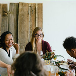 A group of people gathered around a table laughing.