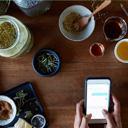 Cell phone receiving text while spices are in different colored bowls around a table